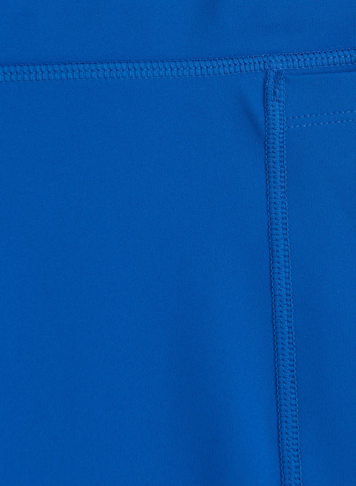 Lähikuva Azure-sinisestä kankaasta ja tasosaumoista näissä aim'n Running Midi Biker Shortseissa.