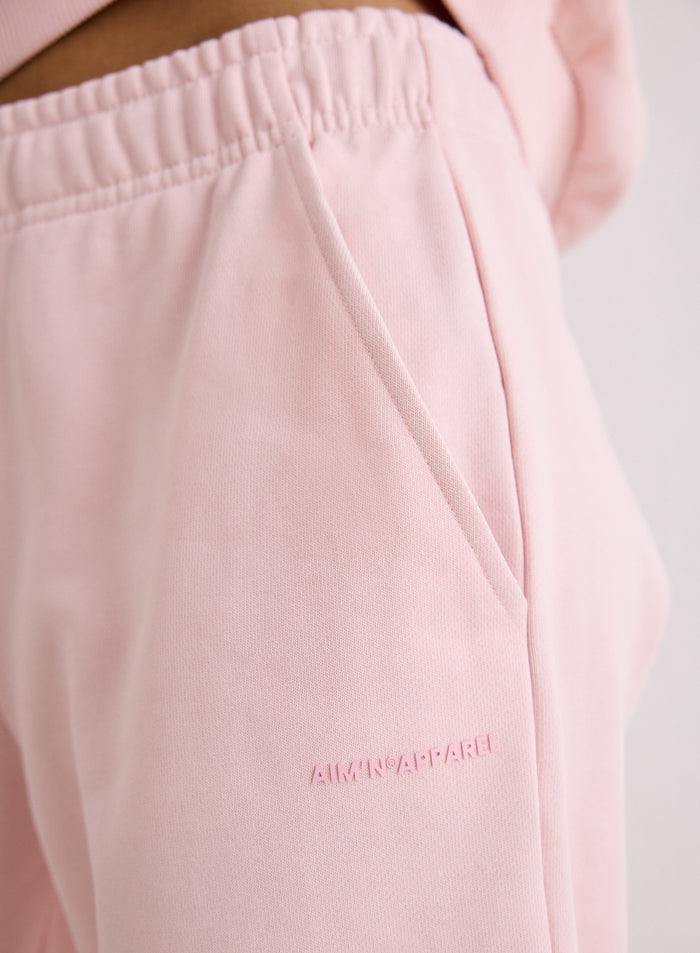 Lähikuva vaaleanpunaisten Chunky Terry Sweatpants -collegehousujen taskusta ja logosta [S-170cm]