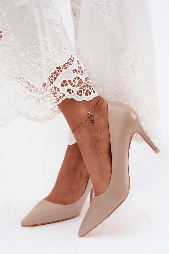 beige patent heels with pointed toe design worn with lace-trimmed white pants