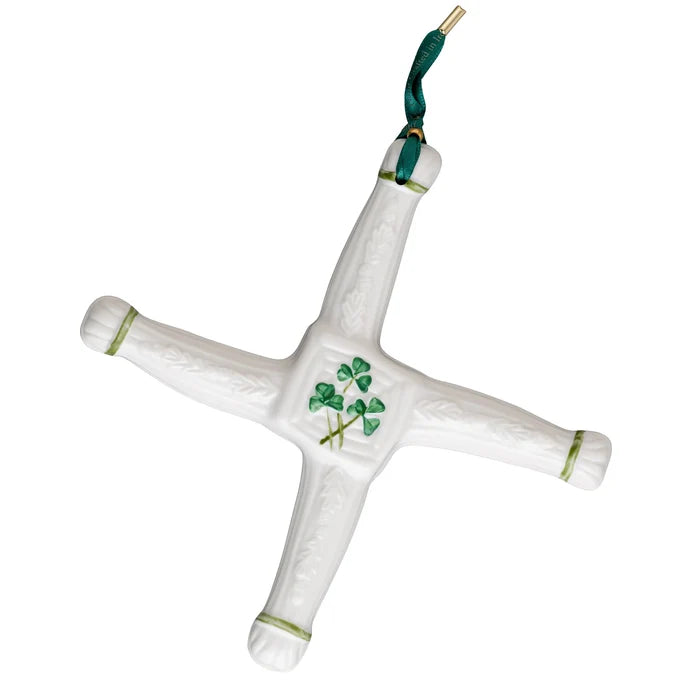 White ceramic cross with green accents and clover design on a white background