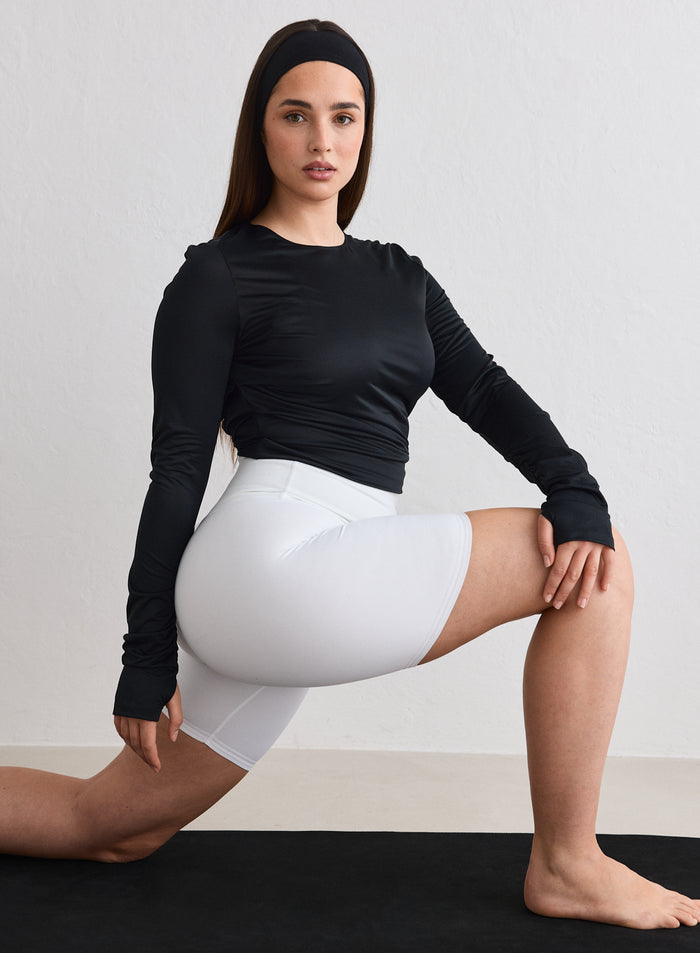 Malli yllään musta aim'n Luminous Draped Long Sleeve ja valkoiset shortsit tehdessään askelkyykkyä [L-174cm]