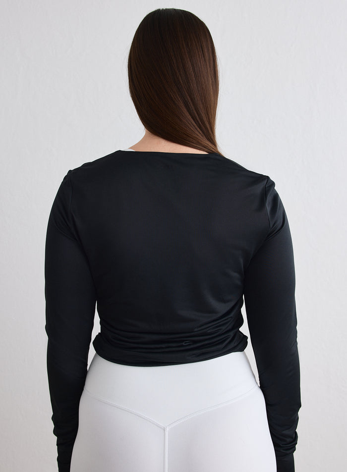 Nainen takaapäin yllään musta aim'n Luminous Draped Long Sleeve [L-174cm]