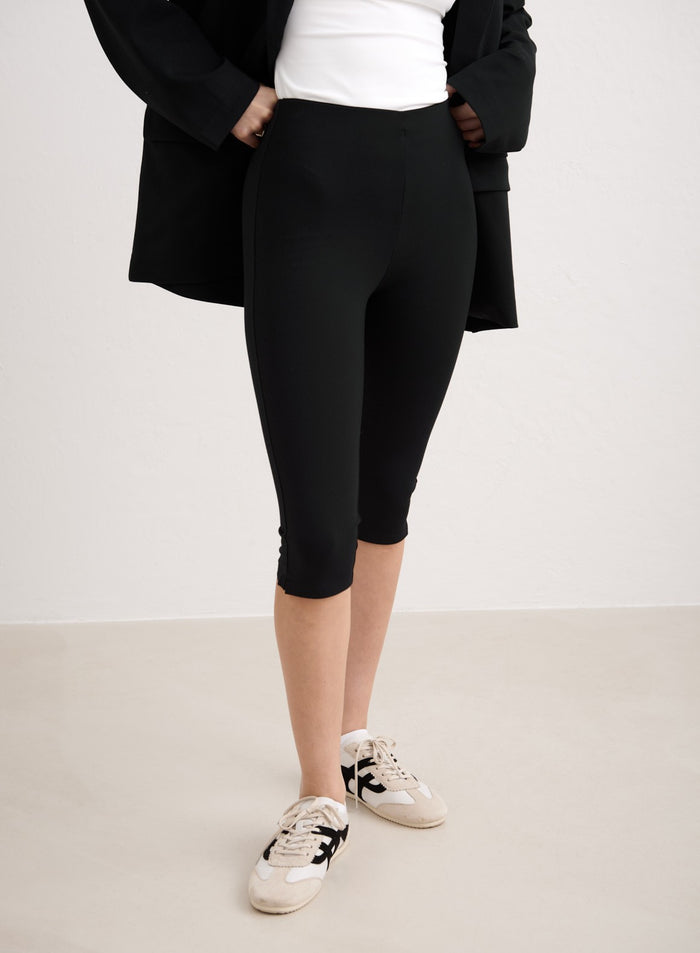 Mustat korkeavyötäröiset aim'n Luxe Capri Pants -housut stailattuina bleiserillä ja tennareilla. [34-174cm]