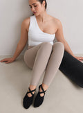 Malli yllään mustat aim'n Pilates Socks -sukat istumassa lattialla.