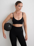 Mustat aim'n Ribbed Seamless Deep Cut Bra -liivit ja leggingsit kuntopalloa pitelevän mallin yllä. [S-165cm]