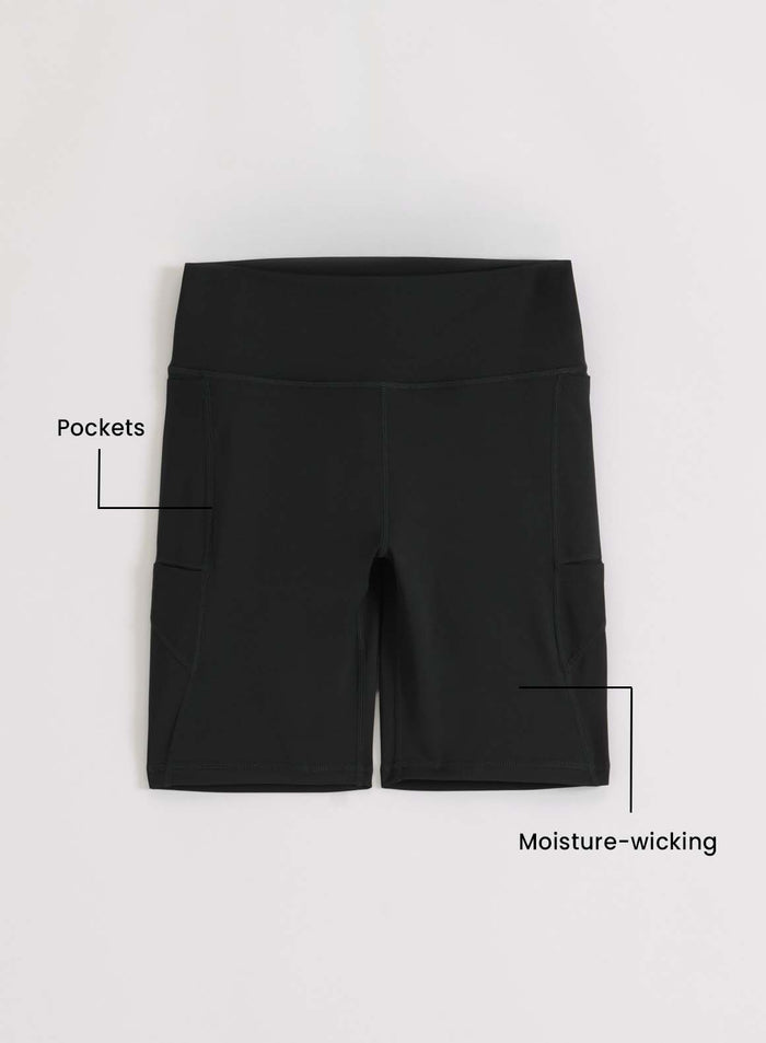 Korkeavyötäröiset mustat aim'n Running Biker Shorts -shortsit sivutaskuilla ja kosteutta siirtävällä kankaalla tasokuvassa.