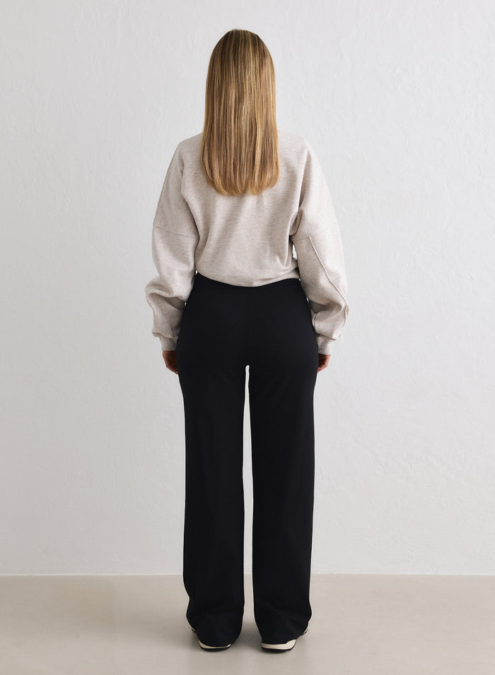 Mustat aim'n Sense Tall Pants -housut takaapäin, rento leveälahkeinen istuvuus ja korkea vyötärö. [M-170cm]