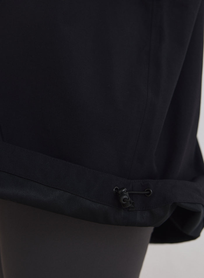Lähikuva Black Waterproof Oversized Anorak -anorakin säädettävästä helmasta ja kiristysnyöristä [M-174cm]
