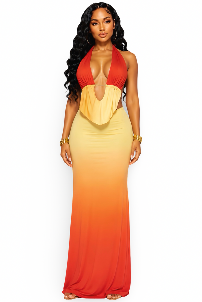 A woman modeling a halter-neck maxi dress with a gradient color-blocked design transitioning from red at the top, through orange, to yellow at the bottom, against a plain white background.