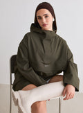 Malli istuu tuolilla yllään aim'n Khaki Waterproof Oversized Anorak ja beiget saappaat [M-174cm]
