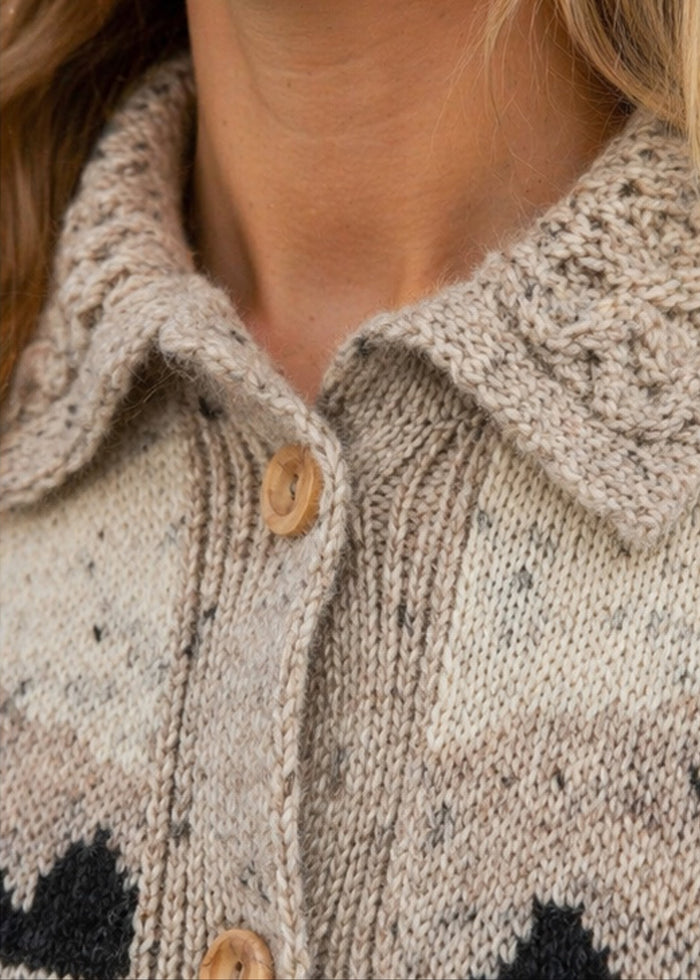Close-up of a person wearing a patterned cardigan with buttons.