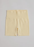 Keltaiset aim'n Shape Seamless Hotpants -shortsit korkealla ribbed-vyötäröllä tasokuvassa.
