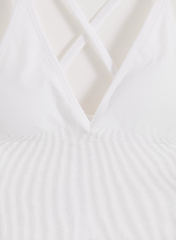 Valkoinen aim'n Shape Seamless Cross Back Bralette V-pääntiellä ja uurretuilla muotoiluyksityiskohdilla.