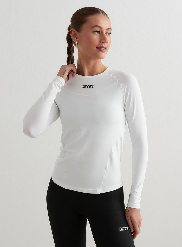 Valkoinen aim'n Soft Basic Long Sleeve -paita raglan-hihoilla ja imartelevalla second skin -tunnulla.