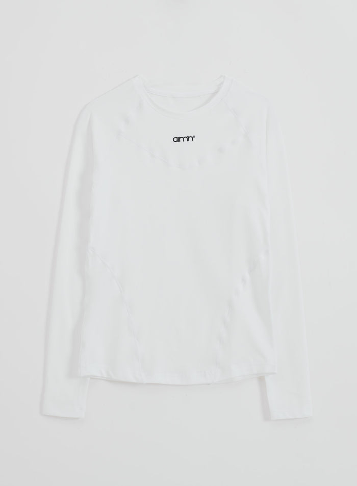 Valkoinen aim'n Soft Basic Long Sleeve -paita raglanhihoilla ja pienellä logolla tasokuvassa.